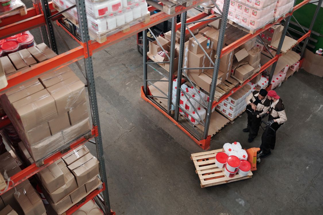 Magazijnmedewerkers beoordelen de voorraad tussen de opslagplanken